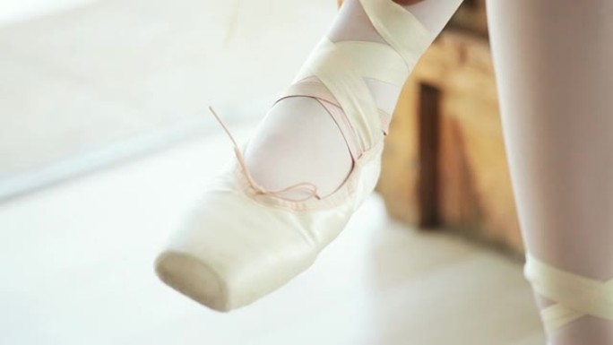 芭蕾舞演员把缎带系在芭蕾舞鞋上