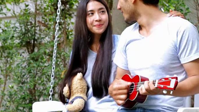 爱情情侣在大自然中弹吉他。