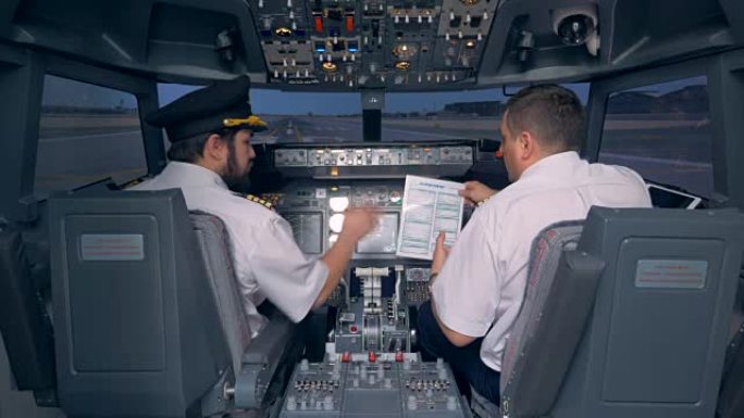飞行员在飞行模拟器的驾驶舱中阅读手册。4K。