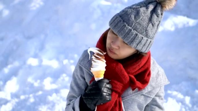 日本北海道小樽的快乐亚洲女人在雪地里吃冰淇淋