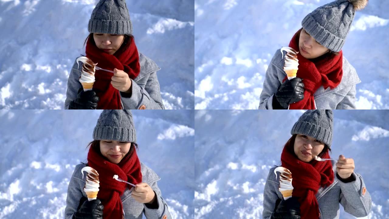 日本北海道小樽的快乐亚洲女人在雪地里吃冰淇淋