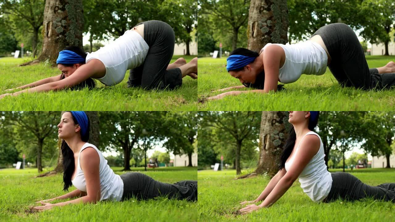 漂亮的黑发女人在公园做瑜伽