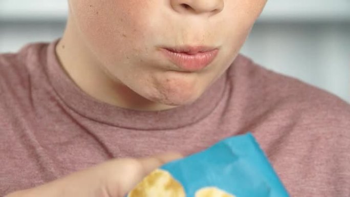 男孩吃一包薯片的特写