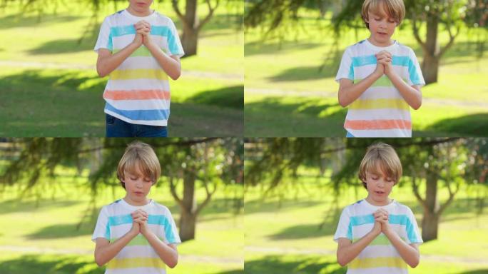 小男孩在公园里祈祷