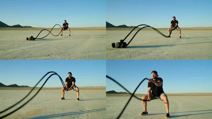 运动男子在沙漠外进行极端的战斗绳索锻炼