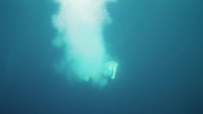 男子跳入水中游泳的水下镜头。在海里潜水。