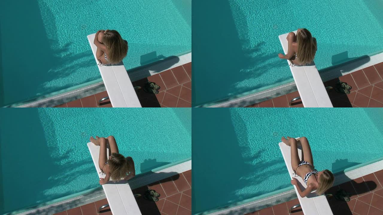 金发女子在跳水板上晒日光浴（使用三角帆）