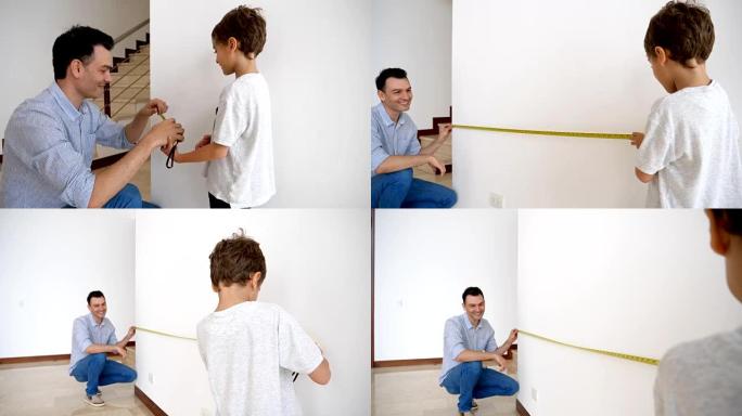 慈爱的爸爸教他的小男孩如何测量一堵墙，指导他看起来非常自豪