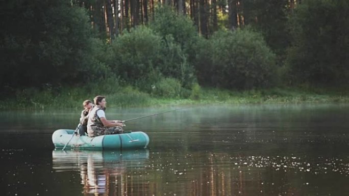 两个费舍尔 (fisher) 爱好，在湖上度过闲暇时光。男子在森林景观上向他的朋友拍摄相机