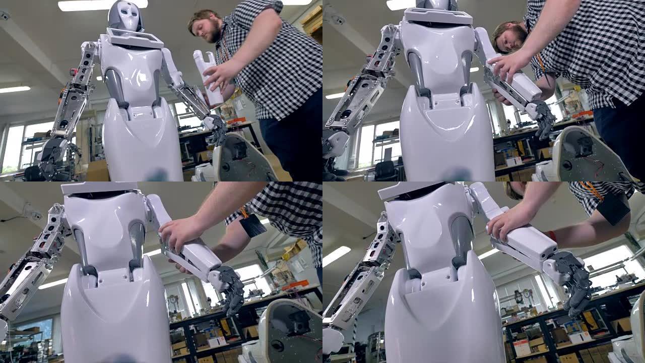 一个年轻的修理工在前臂上覆盖机器人钢架。