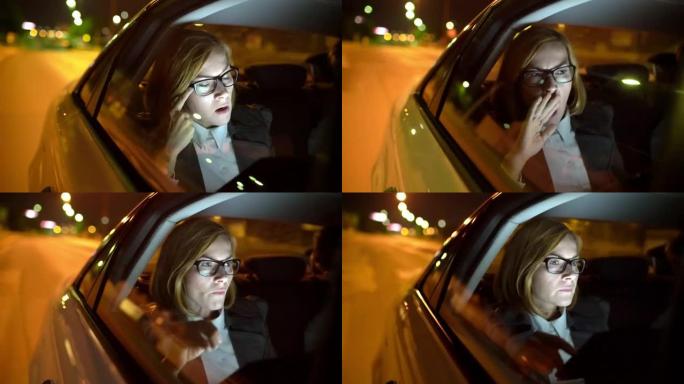 女士疲惫的女商人在夜间驾驶的汽车后座上打哈欠