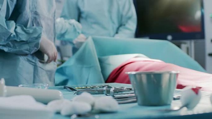 在手术台手术室用器械近距离拍摄，手术期间助手将器械交给外科医生。手术正在进行中。进行手术的专业医生。