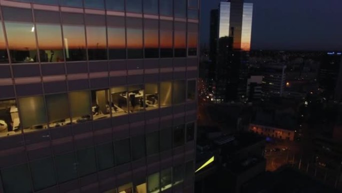 商业区带有广告牌模型的玻璃办公楼的空中轨道拍摄
