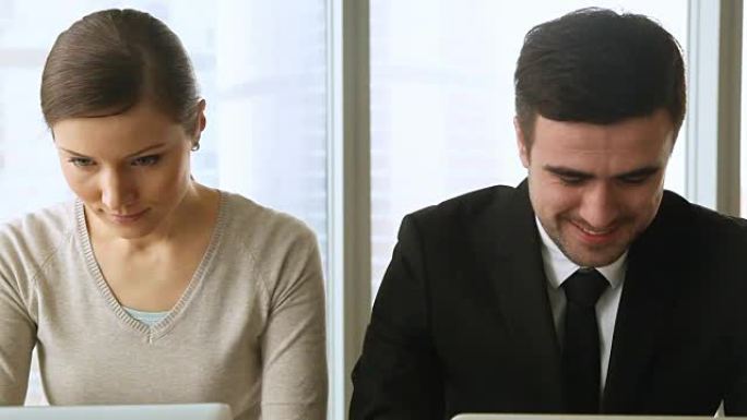 一名好奇的女性偷窥正在看他笔记本电脑屏幕的男同事