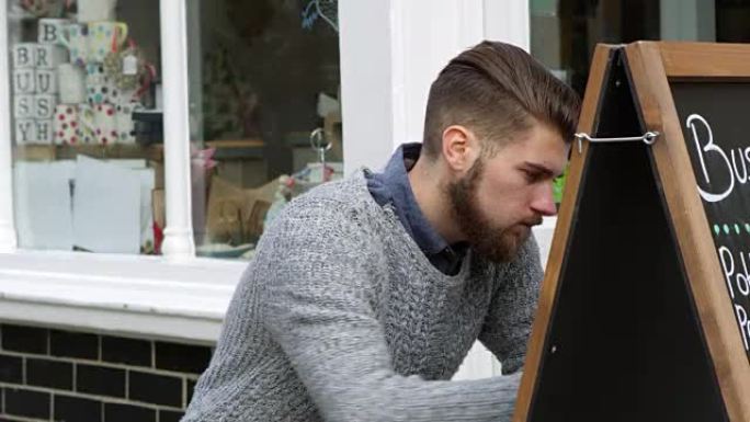 男子在R3D上拍摄的咖啡店外的布告板上写字