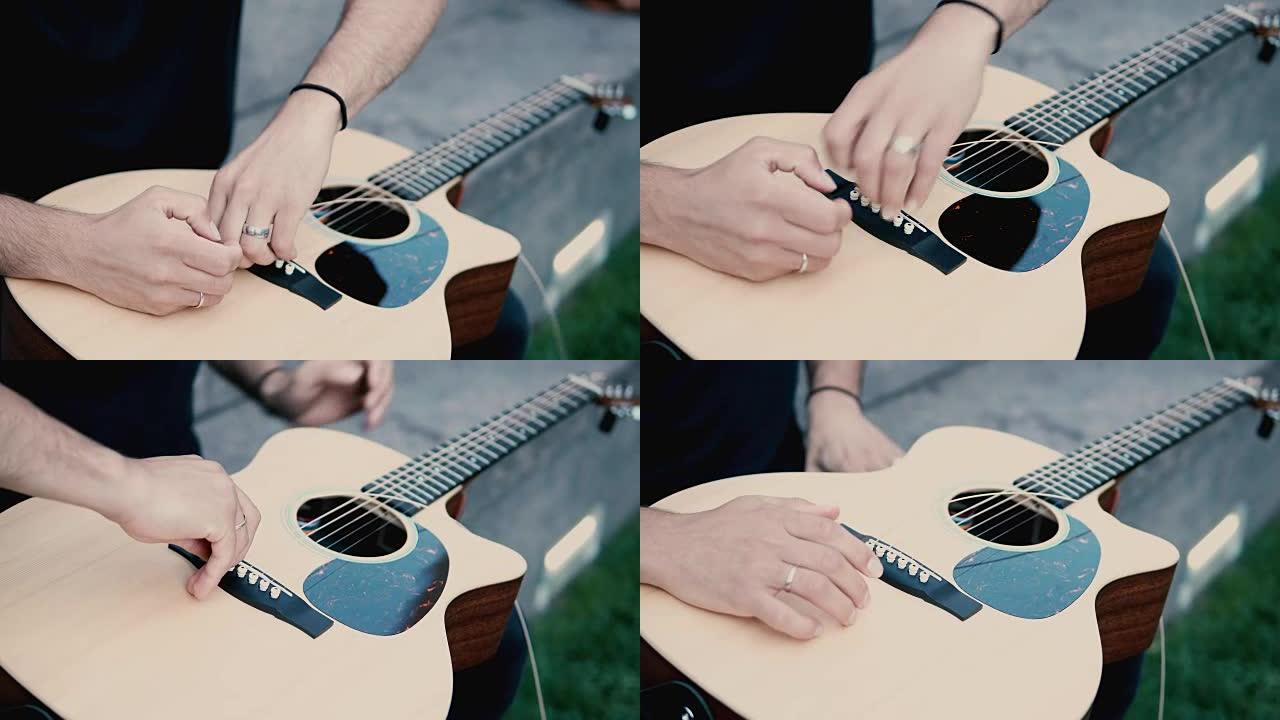 男性手握吉他并进行修复的特写视图。音乐家改变乐器上的弦