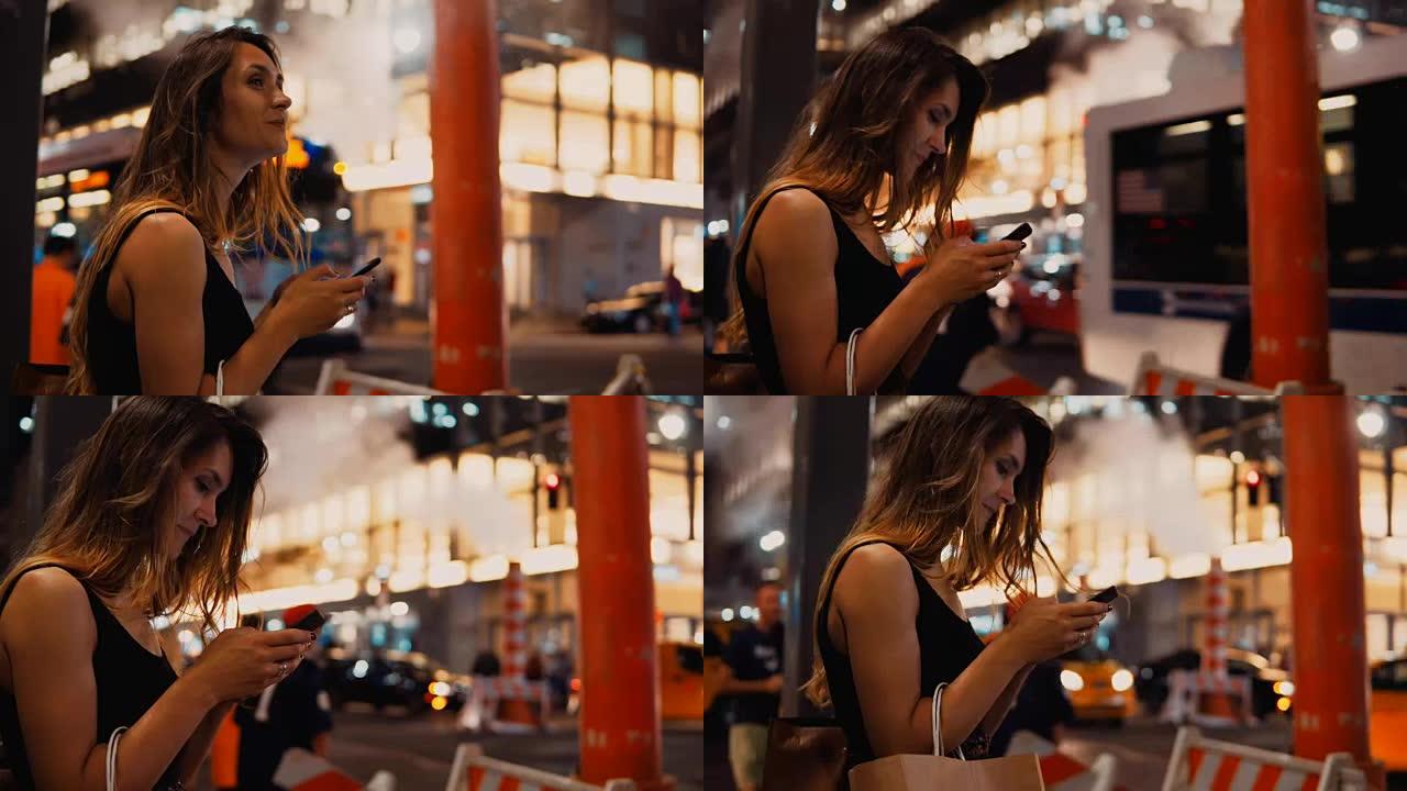 年轻快乐的女人，带着购物袋站在纽约市中心的烟雾管道附近，并使用智能手机