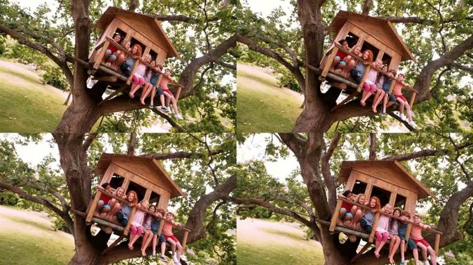 一排坐在木制树屋上的孩子