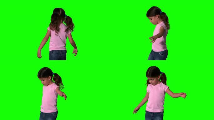 可爱的小女孩在绿色屏幕上旋转