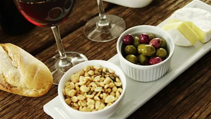一碗花生，橄榄和奶酪配红酒