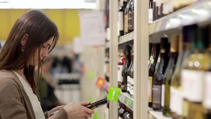 女人在商店的货架上挑选葡萄酒