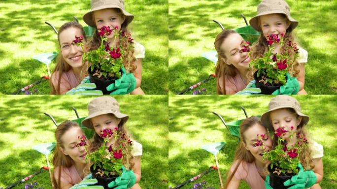 可爱的小女孩和妈妈一起拿着花盆