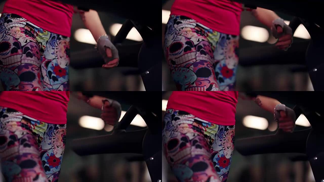 穿着运动紧身裤在跑步机上行走的运动员。穿着运动服的腿部特写