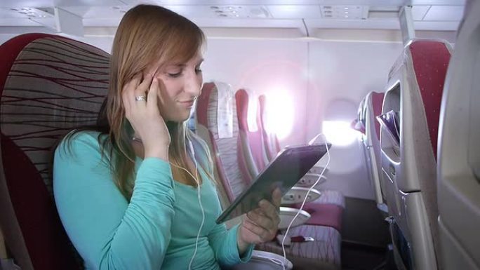 年轻女子在飞机上听音乐