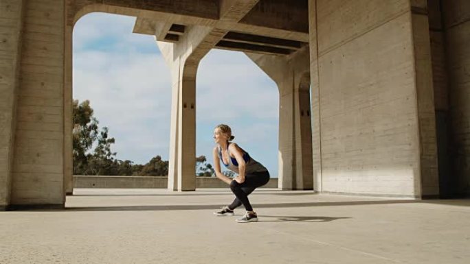年轻健康的女人在阳光明媚的日子在外面锻炼在现代城市环境中伸展运动