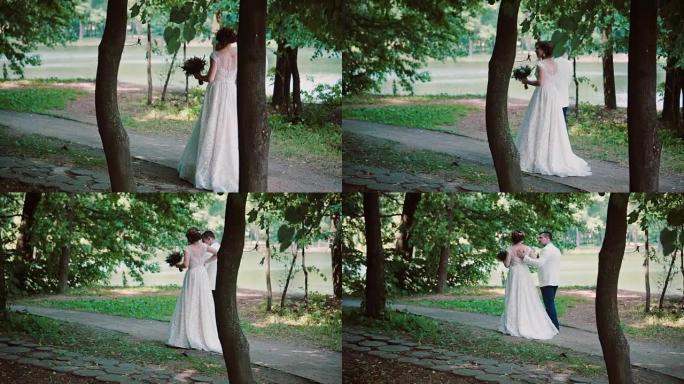 相爱的美丽夫妇分享他们的婚礼，在森林里散步，拥抱，享受阳光明媚的夏日。Steadicam射击