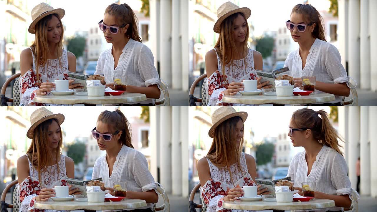 两个女性朋友在伊维萨岛咖啡馆外阅读指南