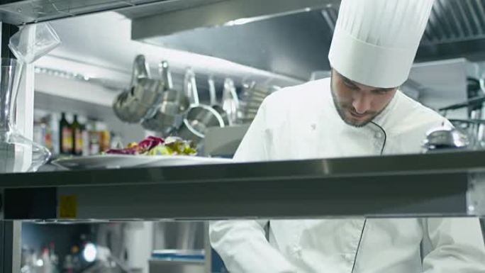 餐厅或酒店的商业厨房中的专业厨师正在切绿色蔬菜。