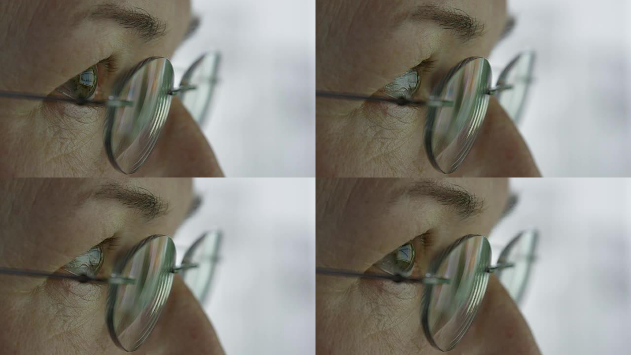 宏观: 监视器在扫描图表时反映在老年妇女的眼睛中