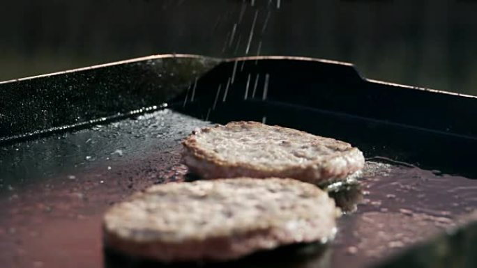 SLO MO调味汉堡在烤架上油炸
