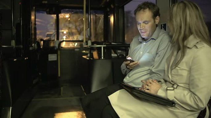 公交车上的通勤者玩数字平板电脑