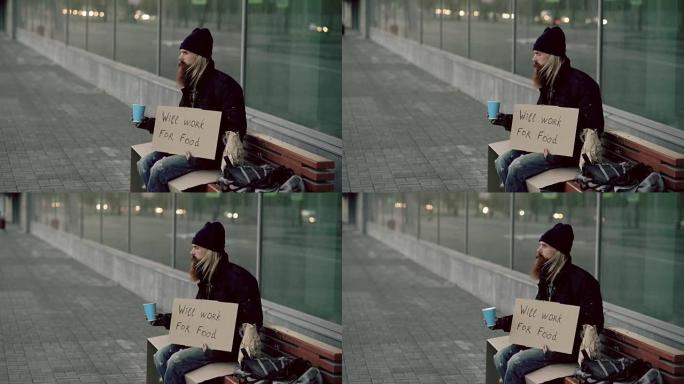 无家可归的年轻人乞求摇钱杯注意人们在城市人行道上的乞丐附近行走