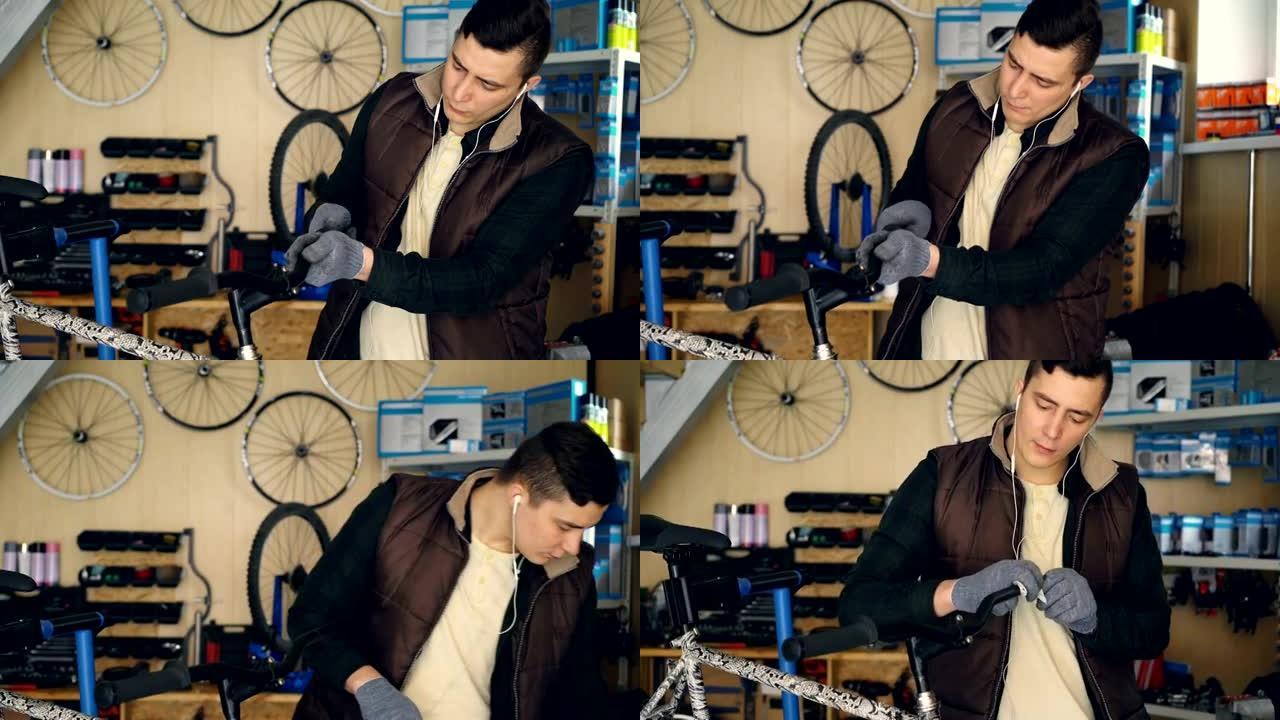 忙碌的服务员在车间维修自行车时，正在拆卸自行车车把并用布清洁零件。Youg man正在用耳机听音乐。