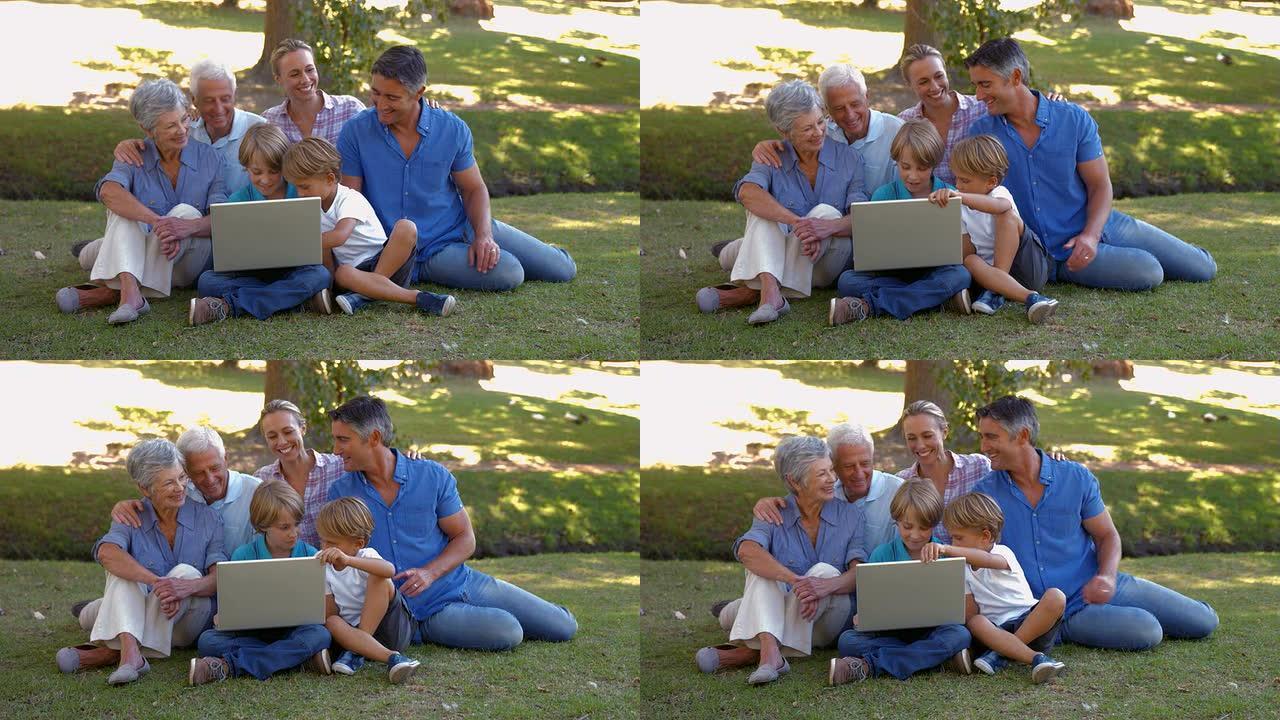 在公园里一起使用笔记本电脑的幸福家庭