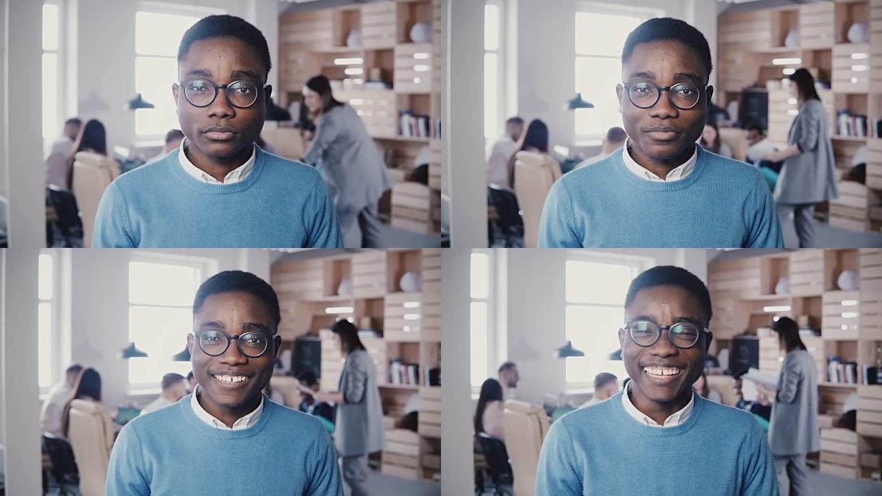 年轻的非洲裔办公室职员戴着眼镜盯着镜头。时尚的平面设计师摆姿势和微笑4K