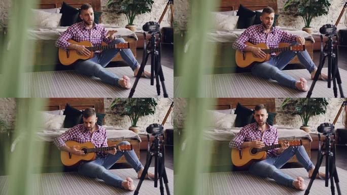 专业音乐家blogger正在录制有关使用相机为互联网博客弹吉他的教程。他正在与追随者交谈，展示乐器，