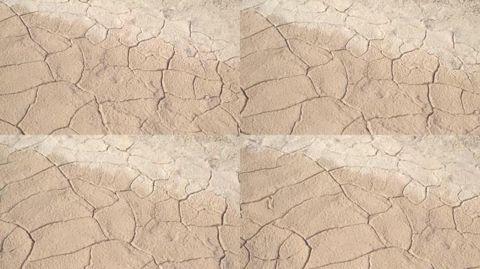 特写: 炎热的阳光沙漠中干燥开裂的干旱土壤的细节