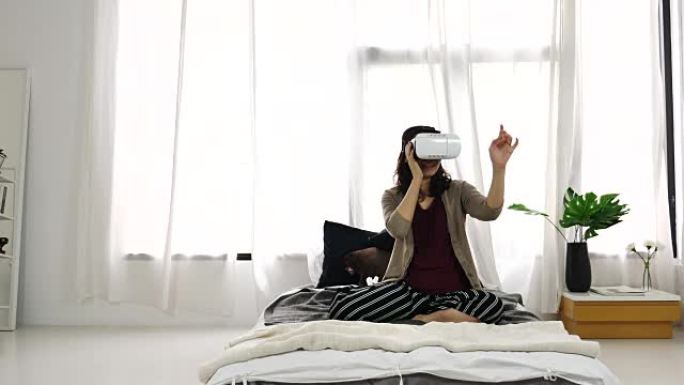 女人在卧室里玩虚拟现实耳机