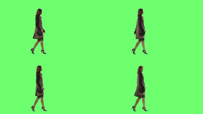 休闲的黑发女性正走在背景的模拟绿色屏幕上。