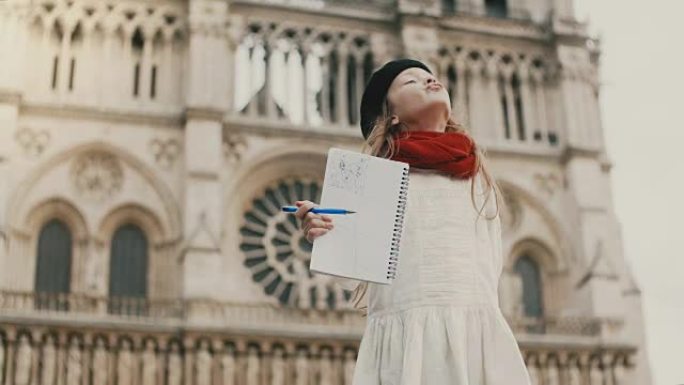 美丽的小女孩在镜头前微笑着展示她的照片。法国巴黎巴黎圣母院附近的快乐孩子