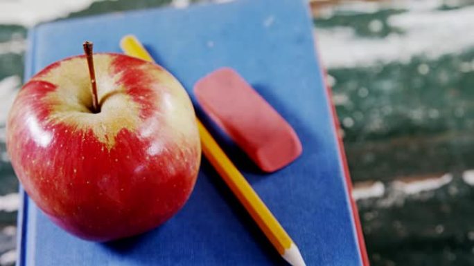 书堆上的苹果，铅笔和橡皮擦
