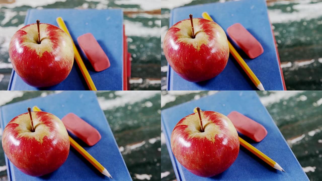 书堆上的苹果，铅笔和橡皮擦