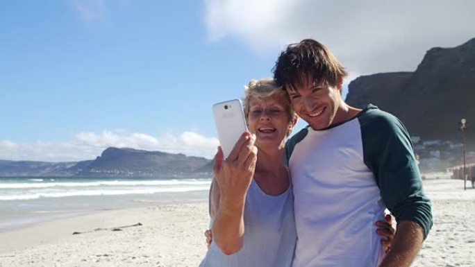 母子俩在海滩用手机自拍