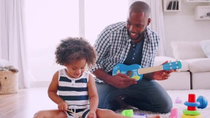 年轻的黑人父亲和他的小女儿在演奏乐器