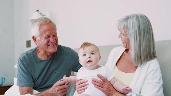 祖母躺在家里的床上照顾小孙子