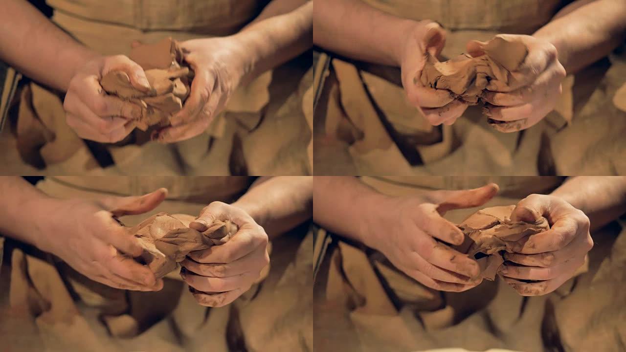 陶艺家的手指揉了一个中等的棕色粘土块。